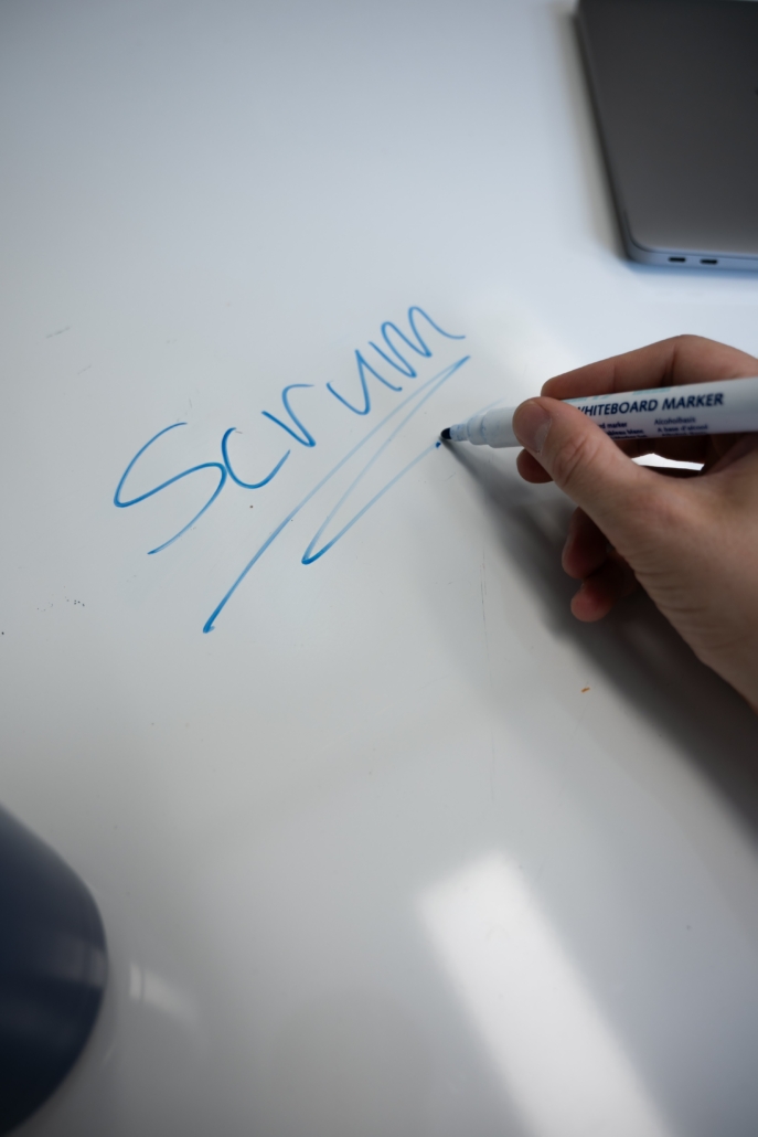 Product owern en scrum master schrijven scrum op whiteboard tijdens een sprint sessie